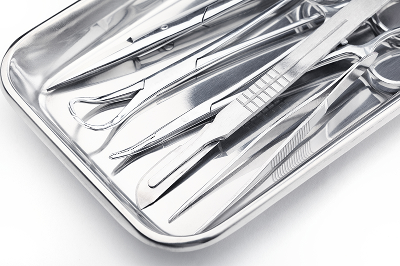 Photograph of a tray of stainless steel surgical instruments